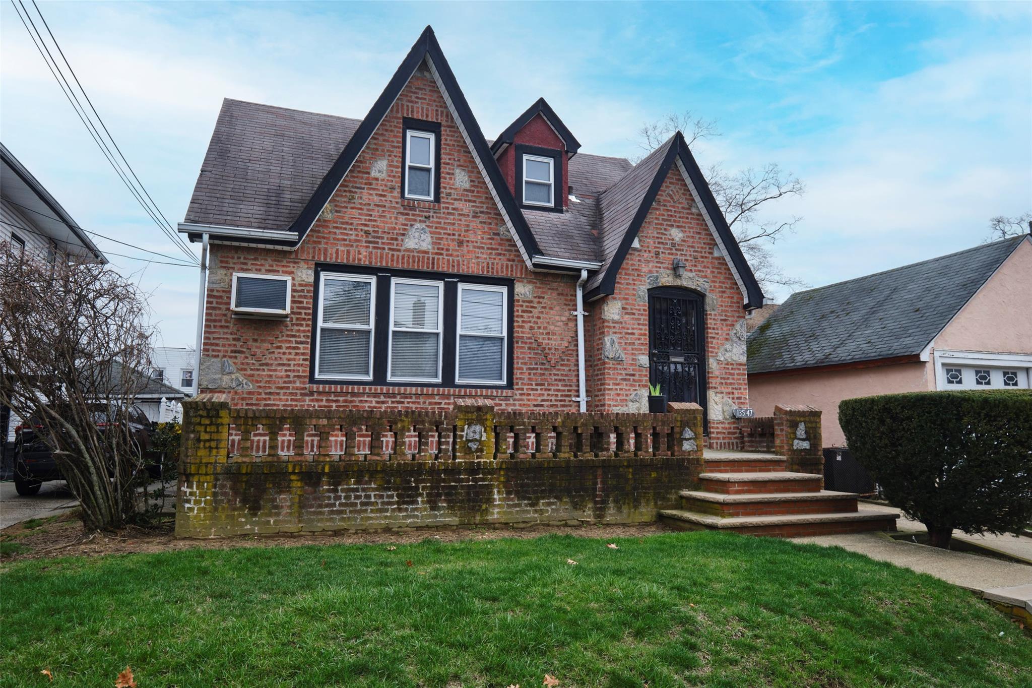 135-47 229th Street Queens, NY 11413 - Photo 36 of 36 Tudor home with brick siding, a front lawn, and roof with shingles