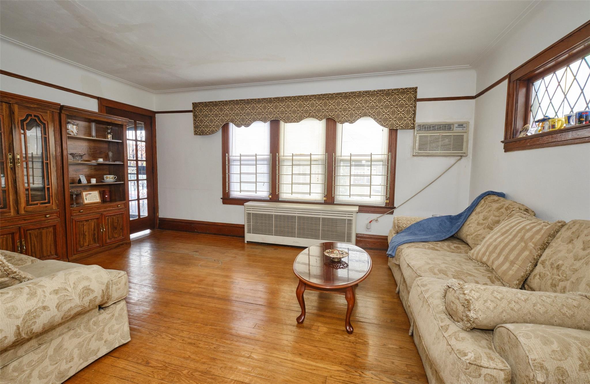 135-47 229th Street Queens, NY 11413 - Photo 7 of 36 Living room featuring crown molding, wood finished floors, radiator and baseboards