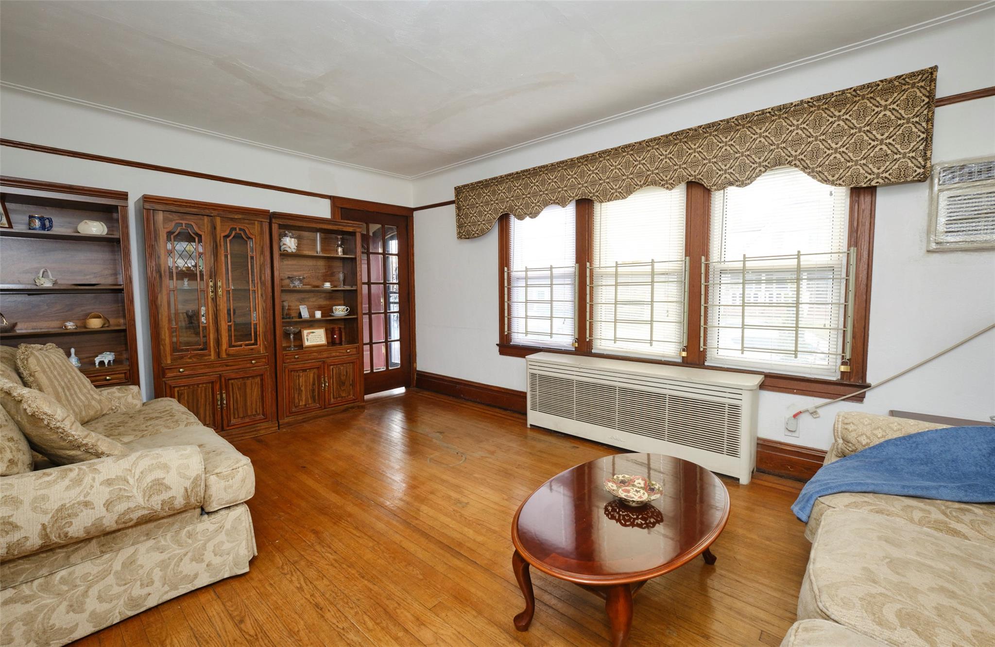 135-47 229th Street Queens, NY 11413 - Photo 9 of 36 Living room with base boards, wood finished floors, and radiator