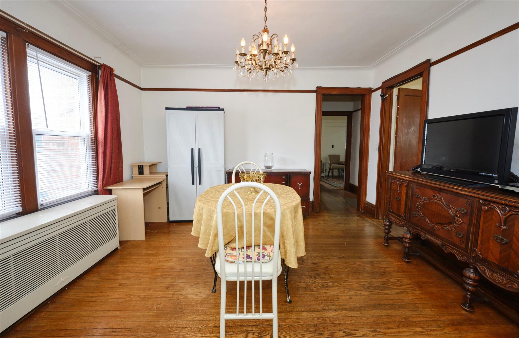 135-47 229th Street Queens, NY 11413 - Photo 10 of 36 Dining area featuring radiator heating unit, arched walkways, hardwood / wood-style flooring, and a chandelier