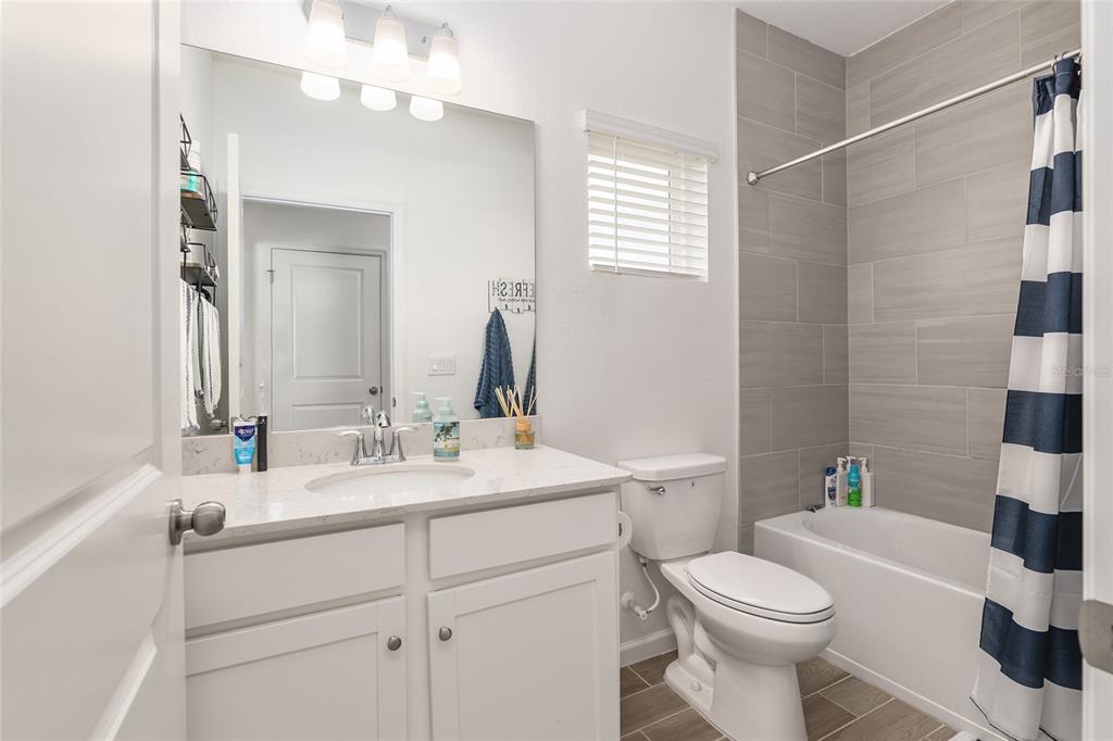 5688 Southwest 92nd Place Ocala, FL 34476 - Photo 37 of 54 a bathroom with a sink a toilet a mirror and shower