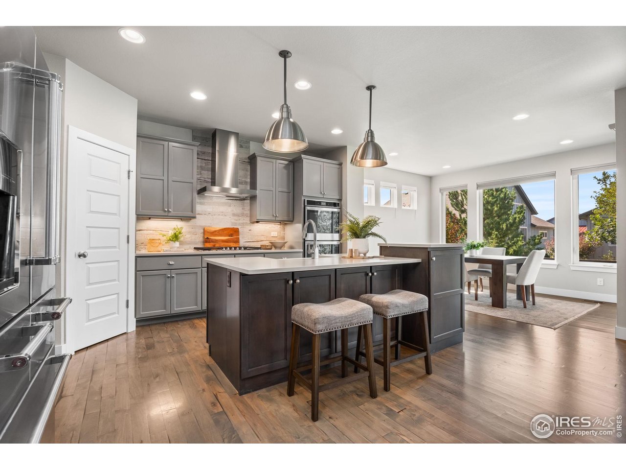 6977 Foxton Court Timnath, CO 80547 - Photo 12 of 32 a kitchen with stainless steel appliances kitchen island granite countertop a sink table and chairs