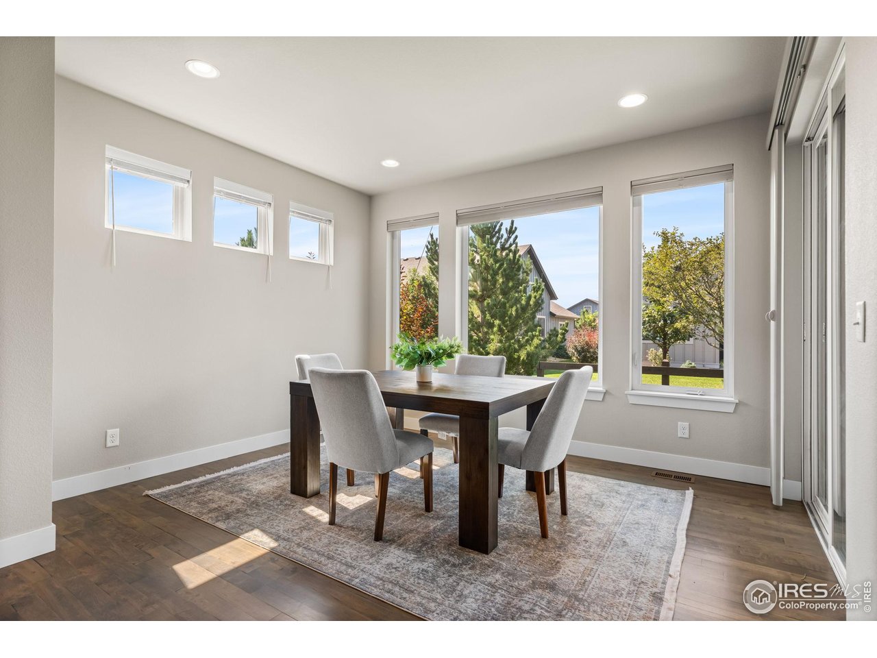 6977 Foxton Court Timnath, CO 80547 - Photo 18 of 32 a dining room with furniture a rug and wooden floor