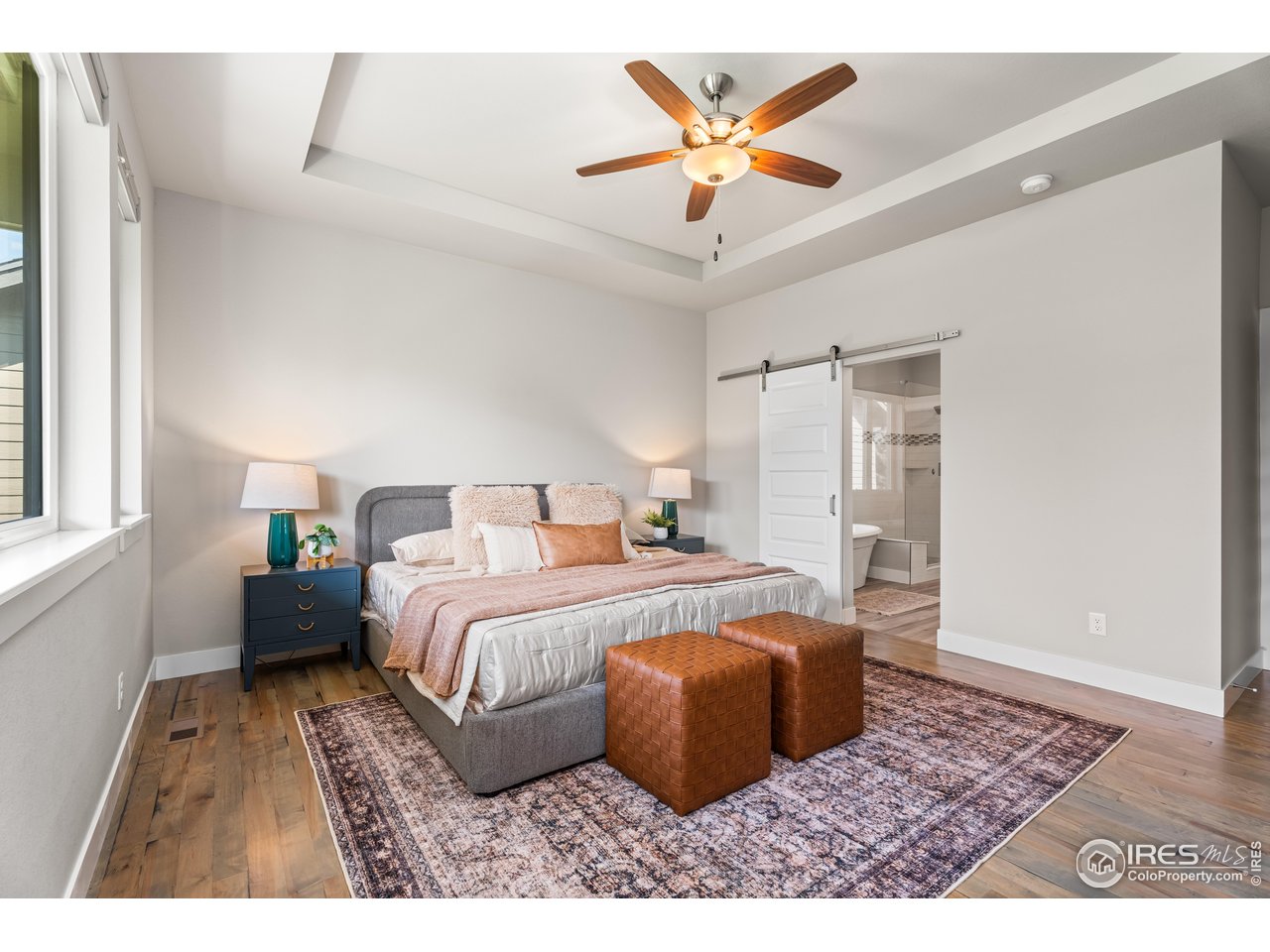 6977 Foxton Court Timnath, CO 80547 - Photo 22 of 32 a spacious bedroom with a bed a rug and a window