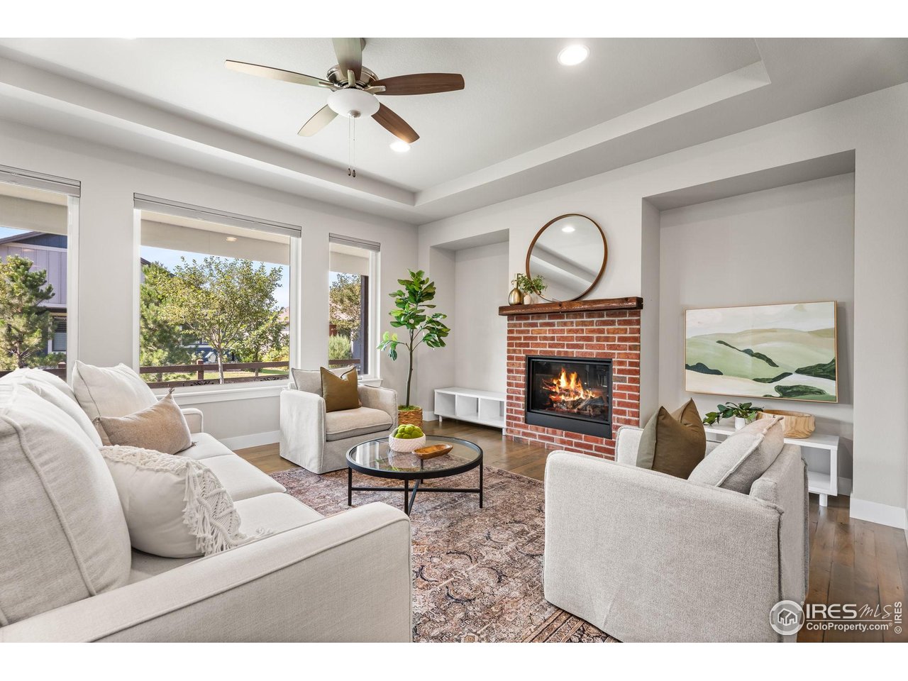 6977 Foxton Court Timnath, CO 80547 - Photo 7 of 32 a living room with furniture a fireplace and a large window