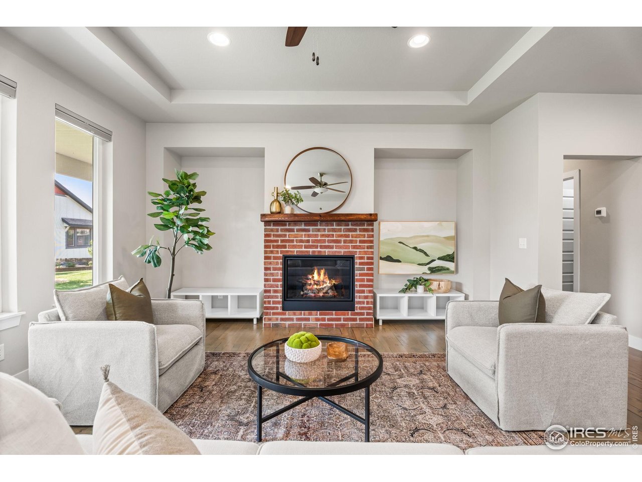 6977 Foxton Court Timnath, CO 80547 - Photo 9 of 32 a living room with furniture a potted plant and a fireplace