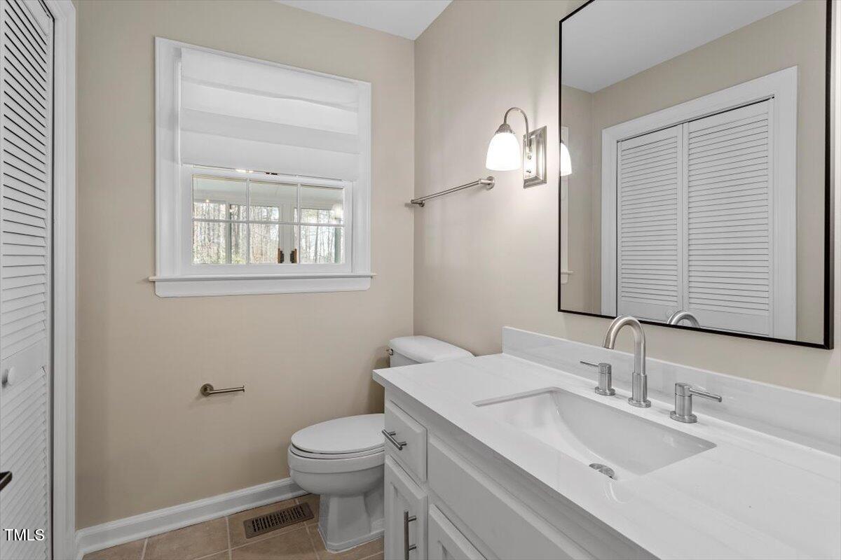 7300 Grist Mill Road Raleigh, NC 27615 - Photo 16 of 41 a bathroom with a toilet a sink and mirror