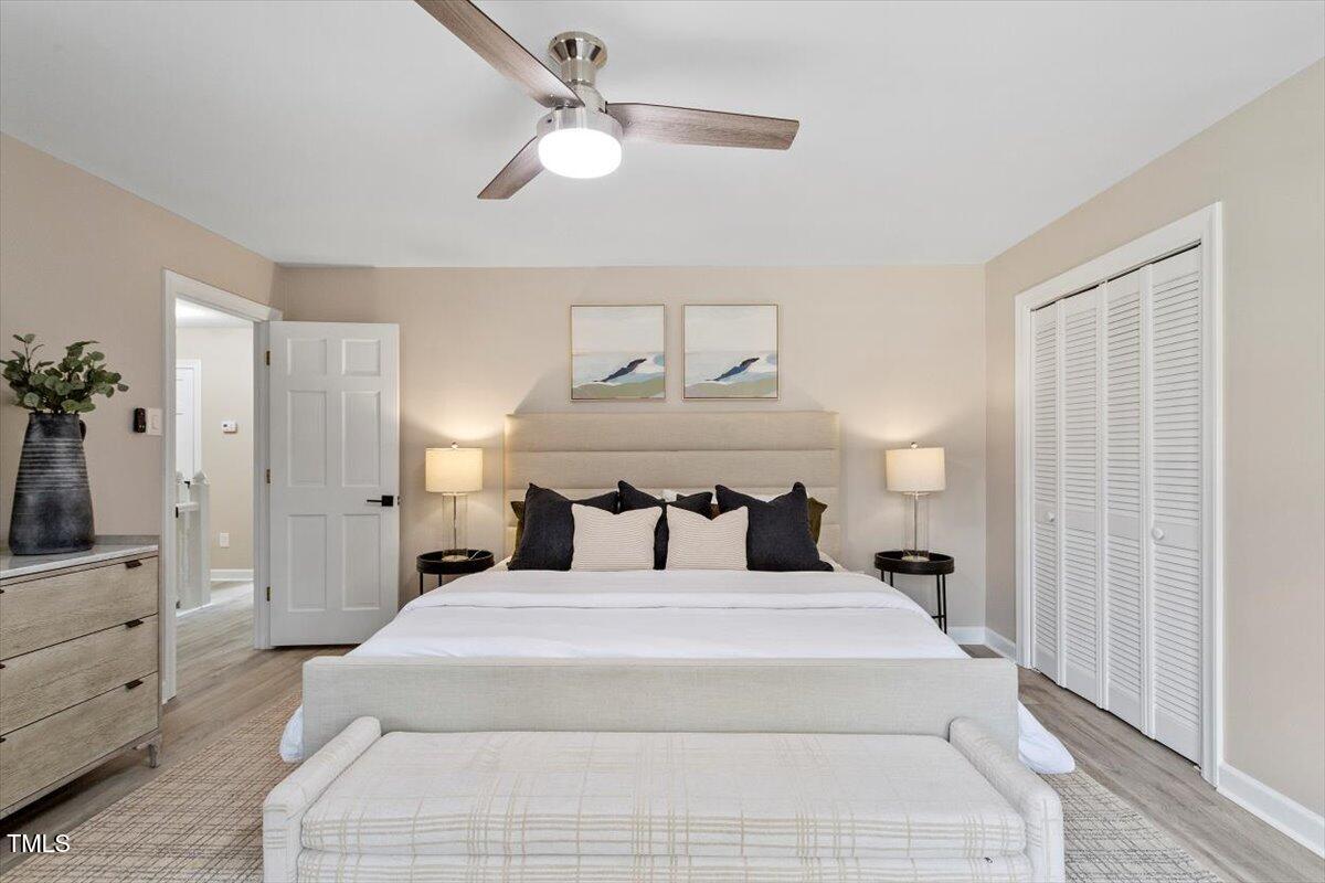 7300 Grist Mill Road Raleigh, NC 27615 - Photo 20 of 41 a bedroom with a large bed and a chandelier