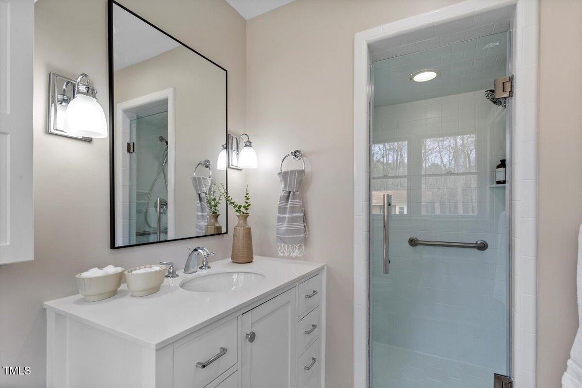 7300 Grist Mill Road Raleigh, NC 27615 - Photo 21 of 41 a bathroom with a sink vanity and mirror