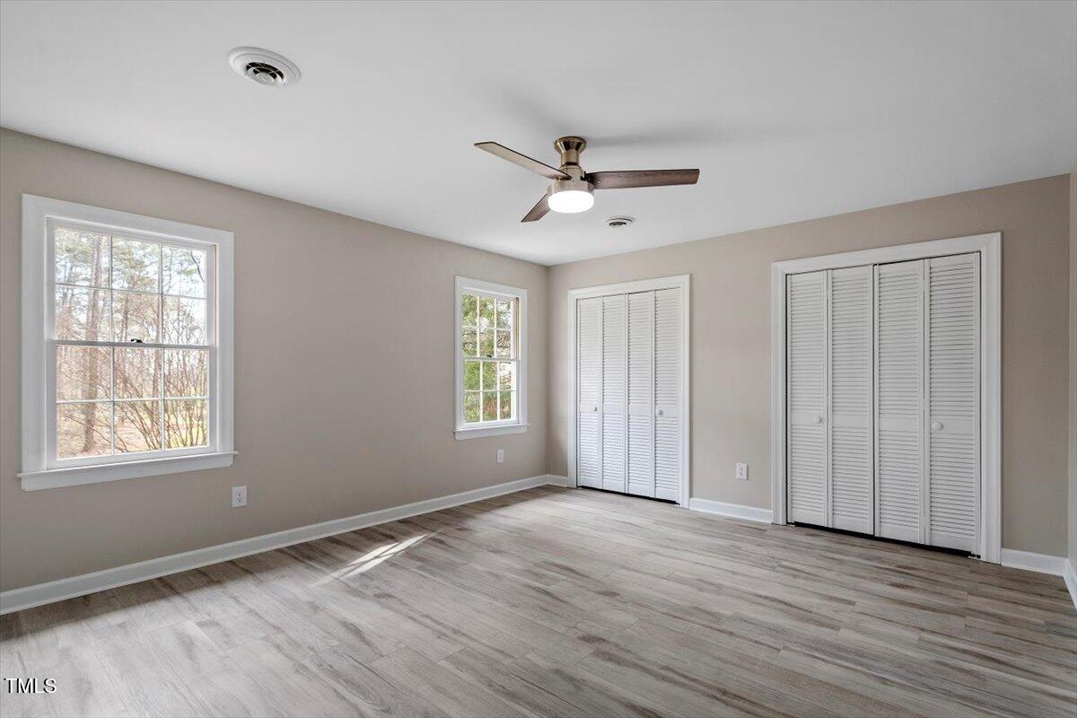 7300 Grist Mill Road Raleigh, NC 27615 - Photo 22 of 41 a view of empty room with wooden floor and fan