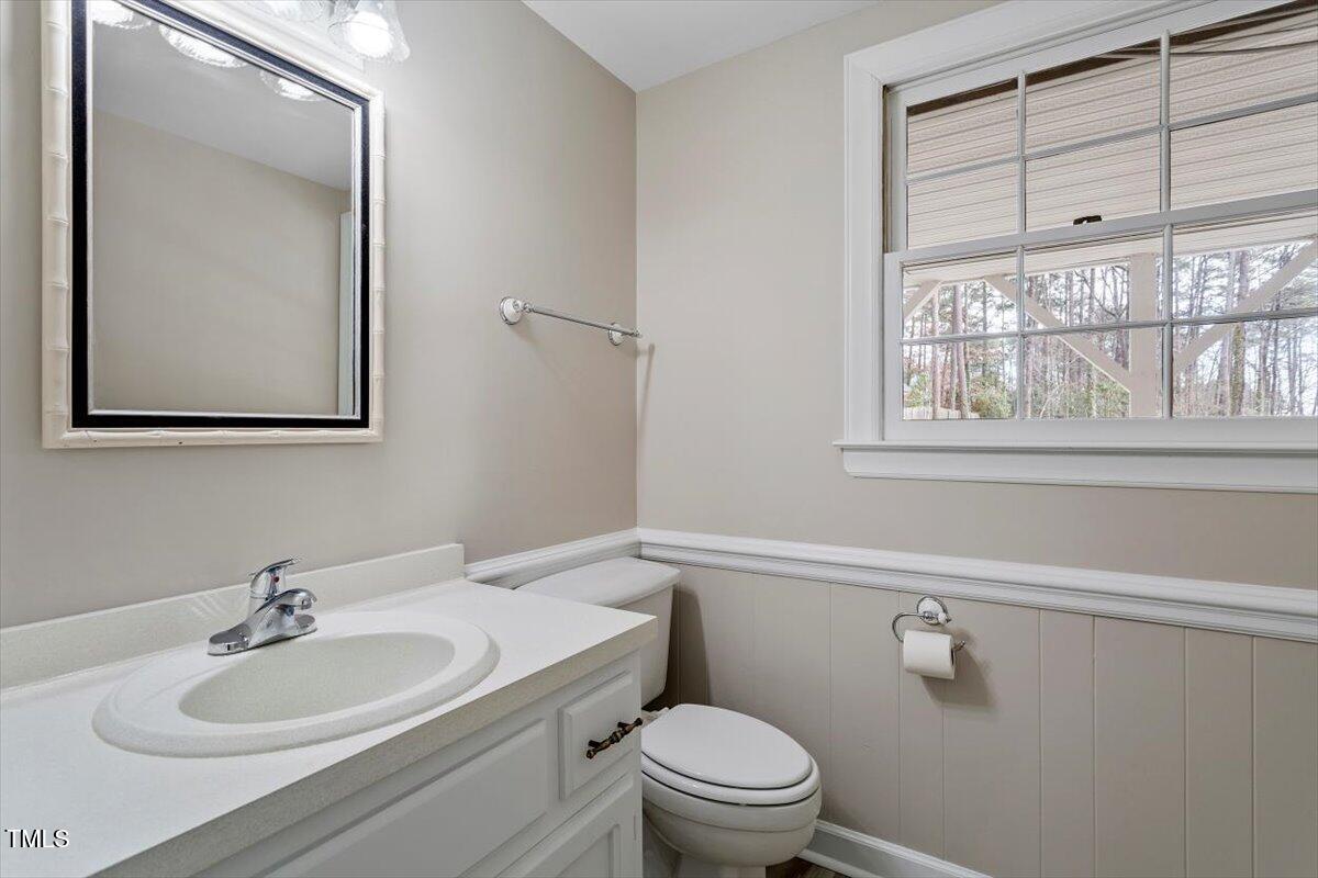 7300 Grist Mill Road Raleigh, NC 27615 - Photo 32 of 41 a bathroom with a toilet a sink a vanity and a mirror