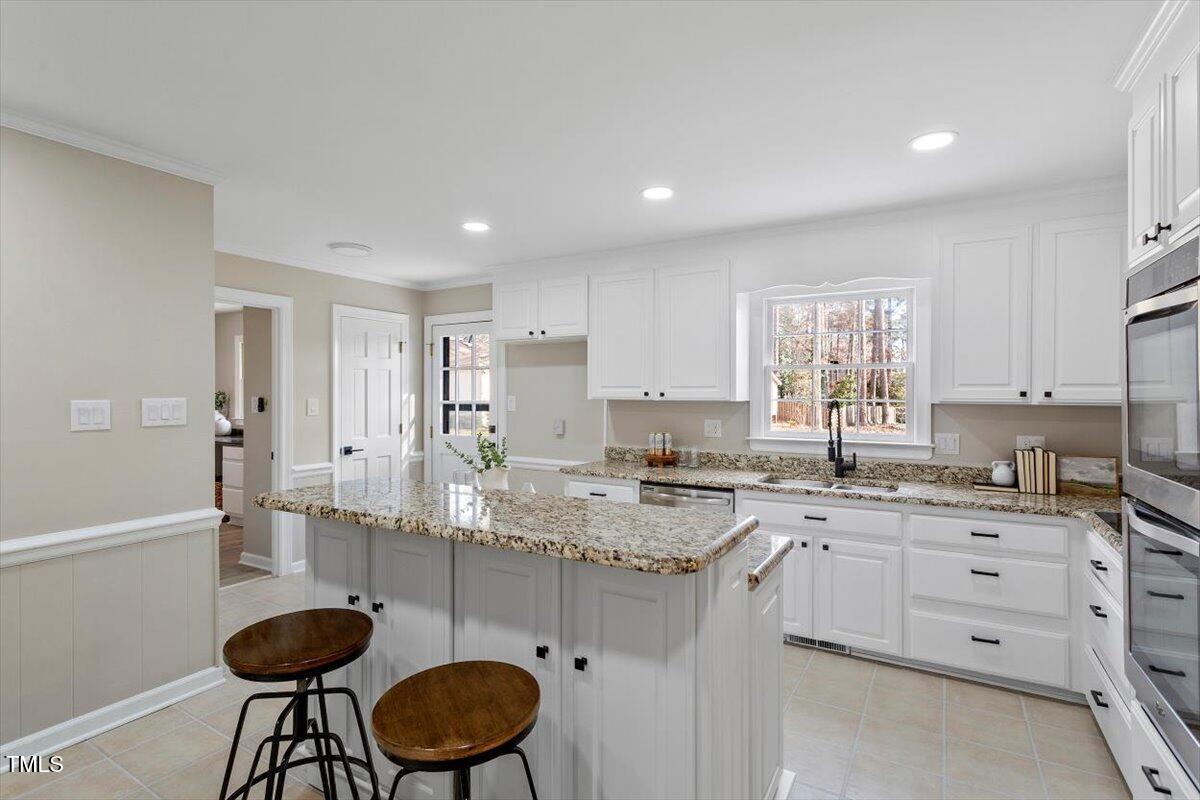 7300 Grist Mill Road Raleigh, NC 27615 - Photo 8 of 41 a kitchen with granite countertop cabinets a table and chairs in it