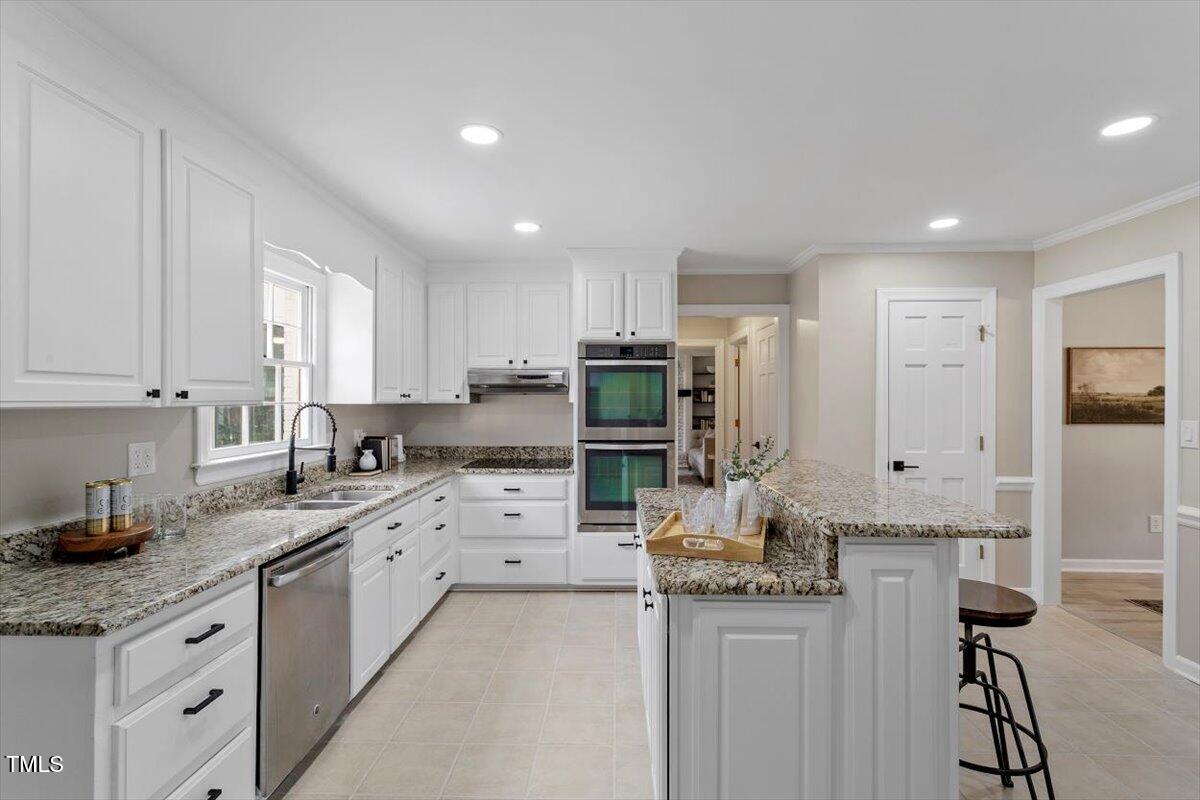 7300 Grist Mill Road Raleigh, NC 27615 - Photo 10 of 41 a kitchen with granite countertop a sink stainless steel appliances and cabinets