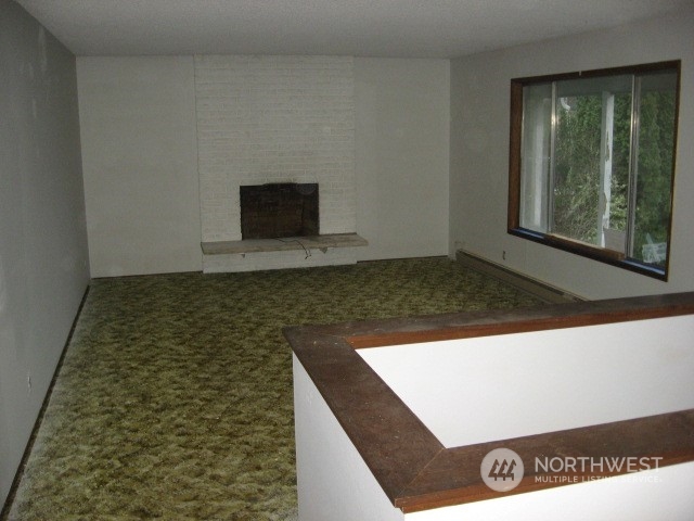 2466 North Shore Road Bellingham, WA 98226 - Photo 6 of 23 a view of an empty room with wooden floor and a fireplace