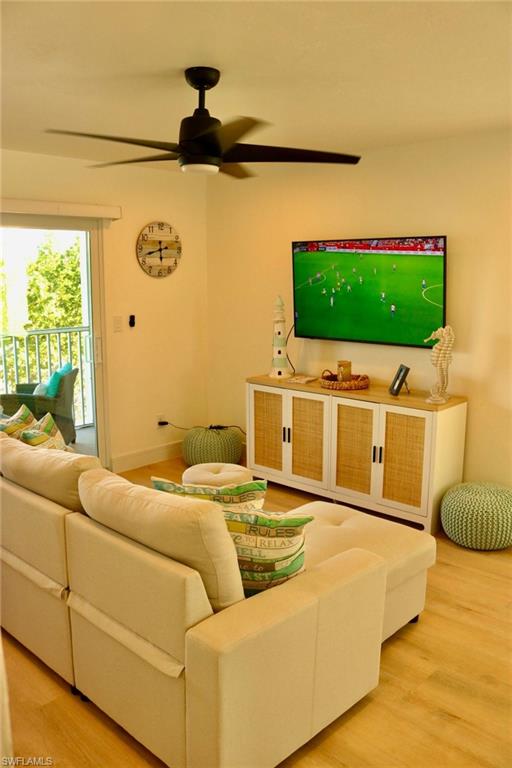2235 San Marco Road, Unit 5204 Marco Island, FL 34145 - Photo 17 of 34 Living area featuring wood-finish flooring, a contemporary ceiling fan with integrated lighting, and a sliding glass door leading to an outdoor space