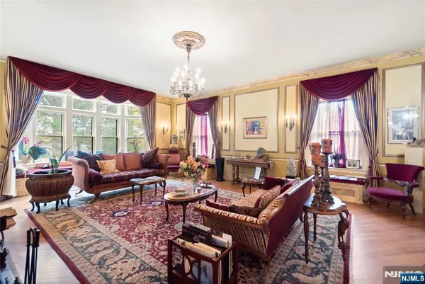 a living room with furniture chandelier and a large window