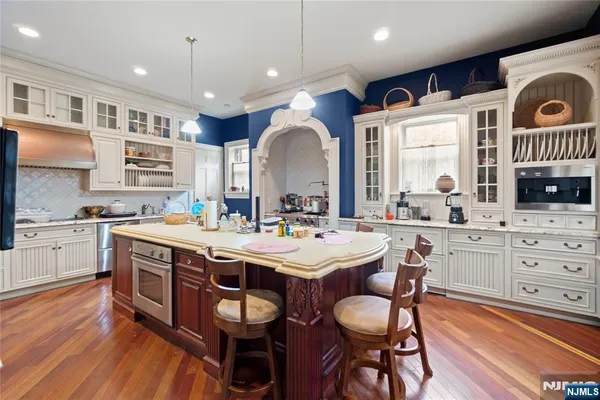 a kitchen with a stove and wooden floor