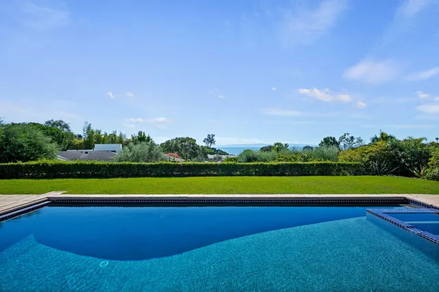 a view of an outdoor space with a swimming pool and tennis court