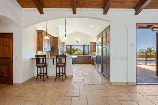 a kitchen with stainless steel appliances kitchen island granite countertop a refrigerator and cabinets