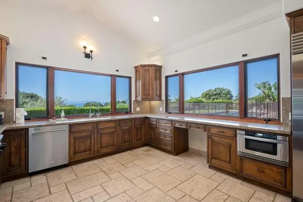 a large kitchen with stainless steel appliances granite countertop a stove a sink and a microwave