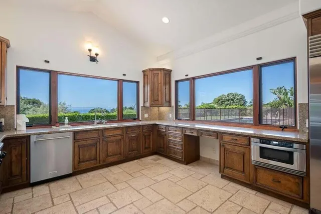 a large kitchen with stainless steel appliances granite countertop a stove a sink and a microwave