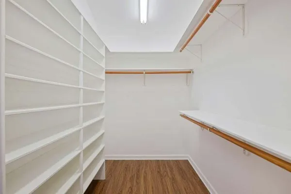 a view of walk in closet with empty racks