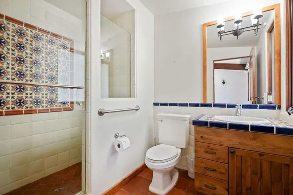 a bathroom with a toilet a sink and mirror