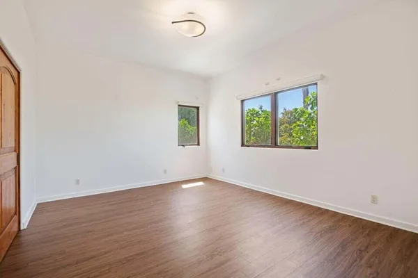an empty room with wooden floor and window