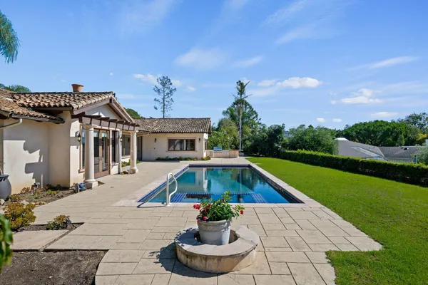 a front view of house with yard swimming pool and green space