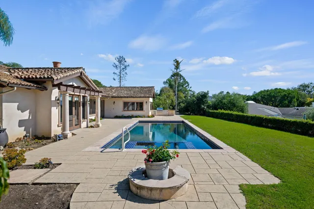 a front view of house with yard swimming pool and green space