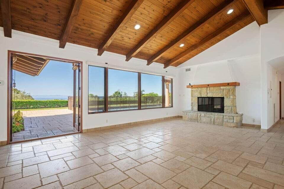 212 Alston Road Santa Barbara, CA 93108 - Photo 8 of 43 a view of an empty room with a fireplace and a ceiling fan
