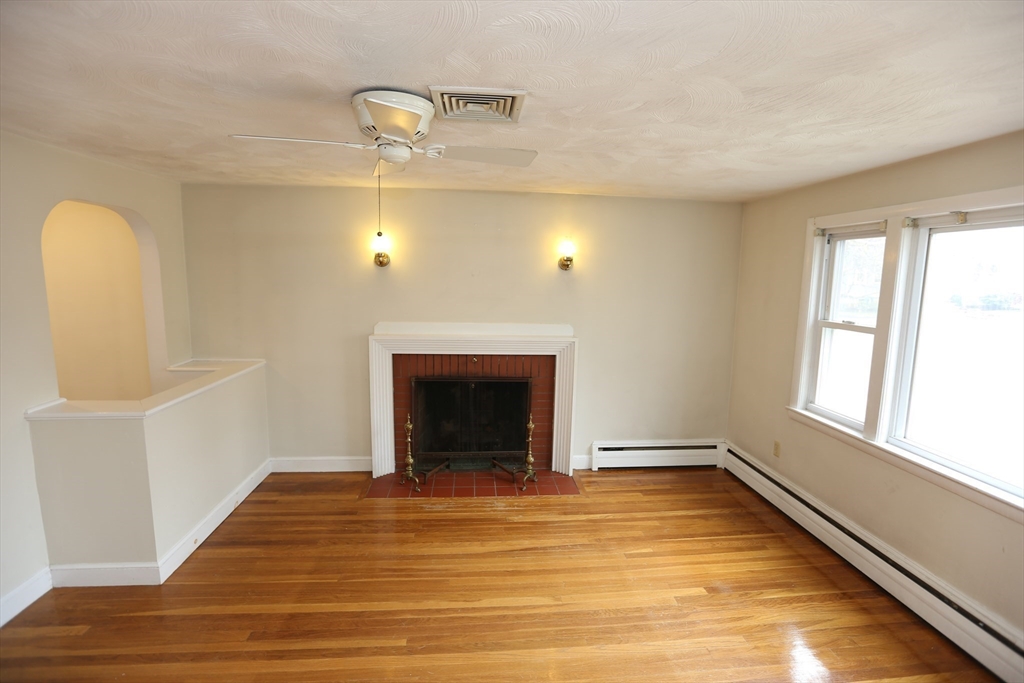 12 Lasell Street Boston, MA 02132 - Photo 2 of 22 a view of an empty room with wooden floor and a window