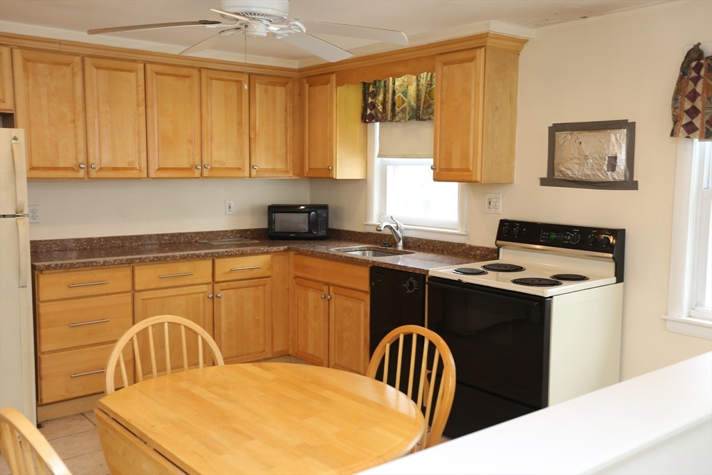 12 Lasell Street Boston, MA 02132 - Photo 7 of 22 a kitchen with stainless steel appliances granite countertop a stove a sink dishwasher and cabinets with wooden floor