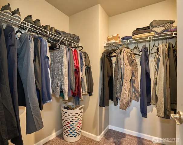 a view of walk in closet with clothes and shoes