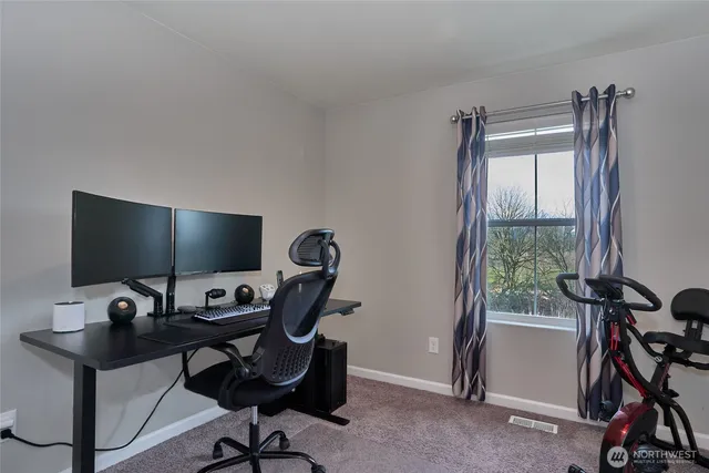 a view of a workspace with furniture and a window