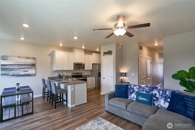 a living room with furniture kitchen view and a chandelier