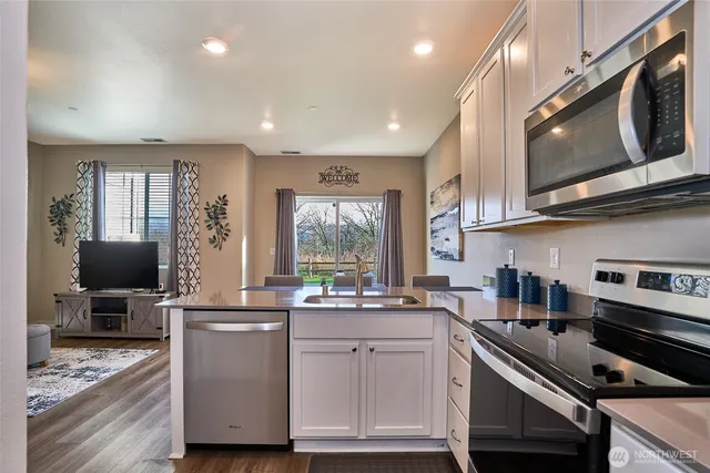 a kitchen with stainless steel appliances a stove microwave and sink