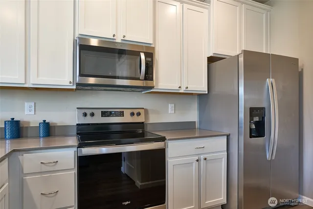 a kitchen with stainless steel appliances granite countertop a stove microwave and refrigerator