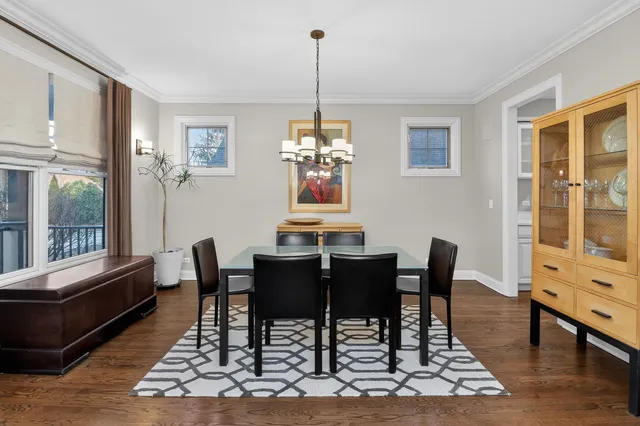 a dining room with furniture a chandelier and wooden floor