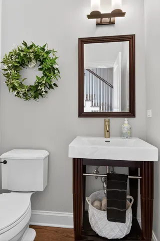 a bathroom with a toilet a sink and mirror