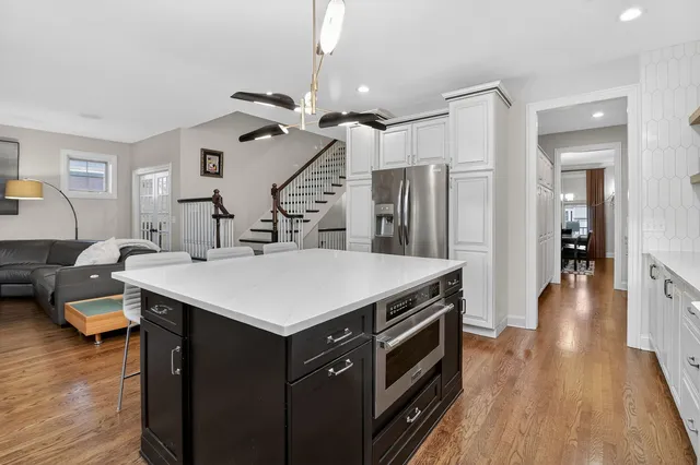 a kitchen with a sink a counter space and wooden floor