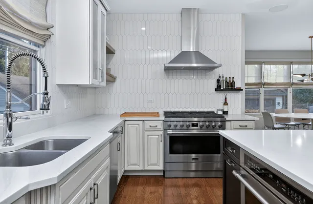 a kitchen with stainless steel appliances a stove a sink and a microwave