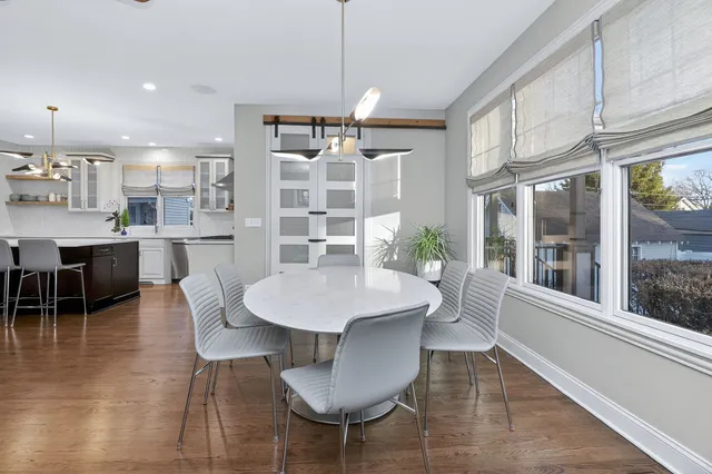 a dining room with furniture a chandelier and kitchen view
