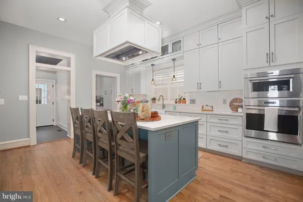 a view of a kitchen that has a sink and dishwasher with white cabinets