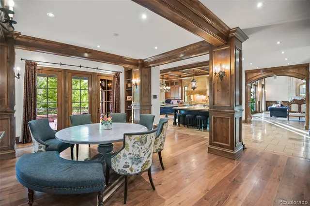 a dining room with furniture a chandelier and wooden floor