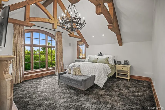 a bed sitting in a spacious bedroom next to a window