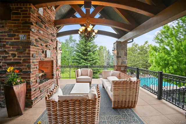 a view of a patio with couches chairs potted plants and wooden fence