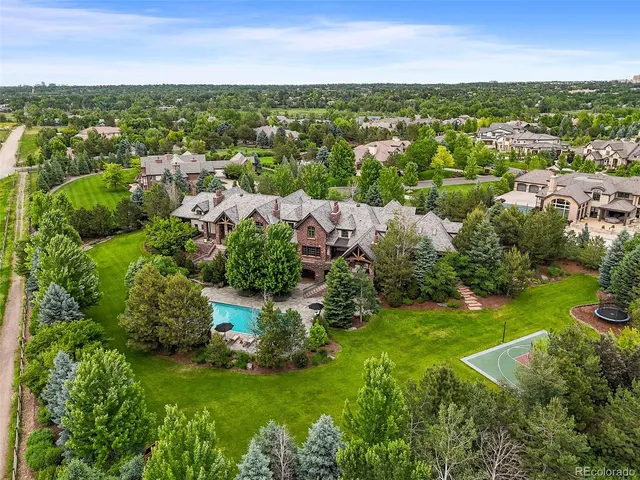 an aerial view of residential houses with outdoor space and trees