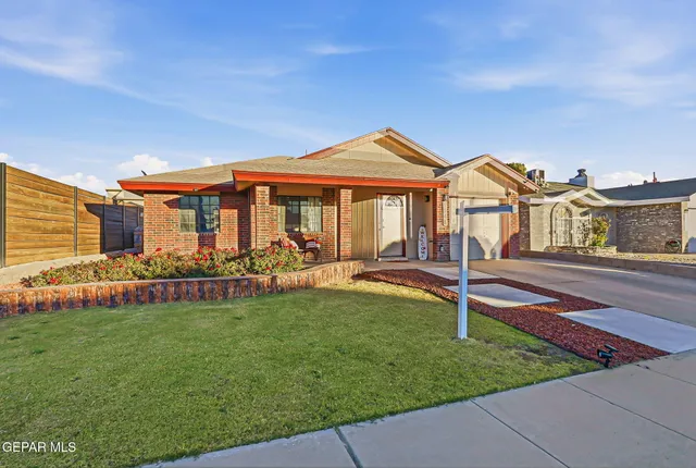 a front view of a house with a garden and yard