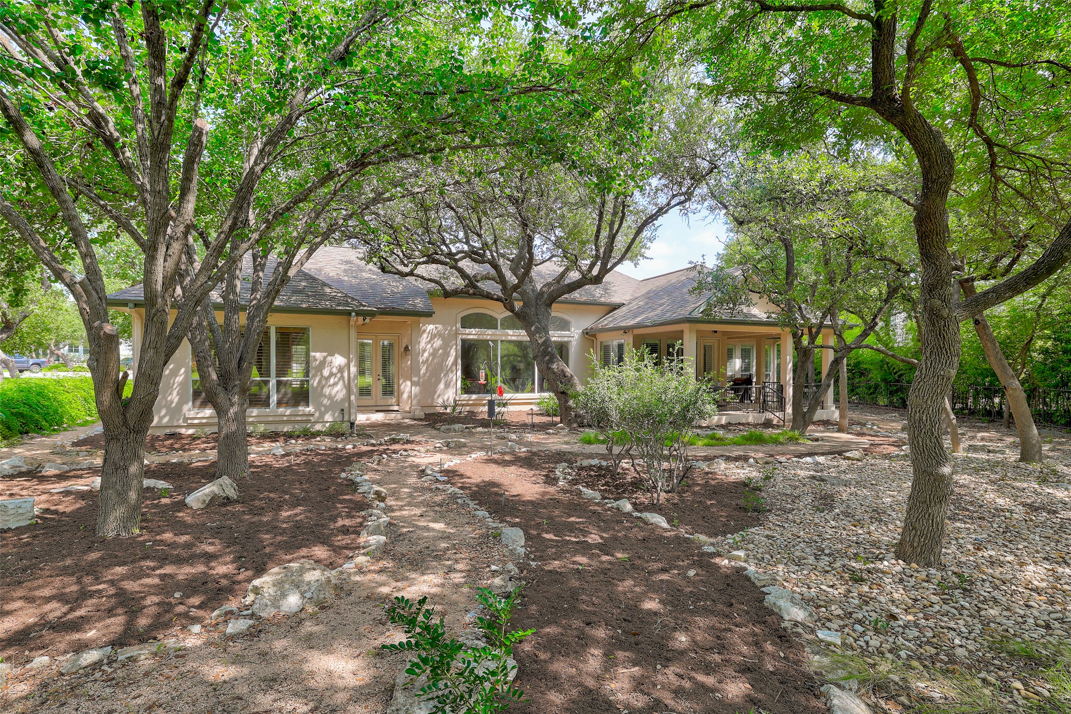 33 Meadows End Georgetown, TX 78628 - Photo 38 of 40 Mature trees frame a charming home with a covered patio, providing a tranquil outdoor retreat.